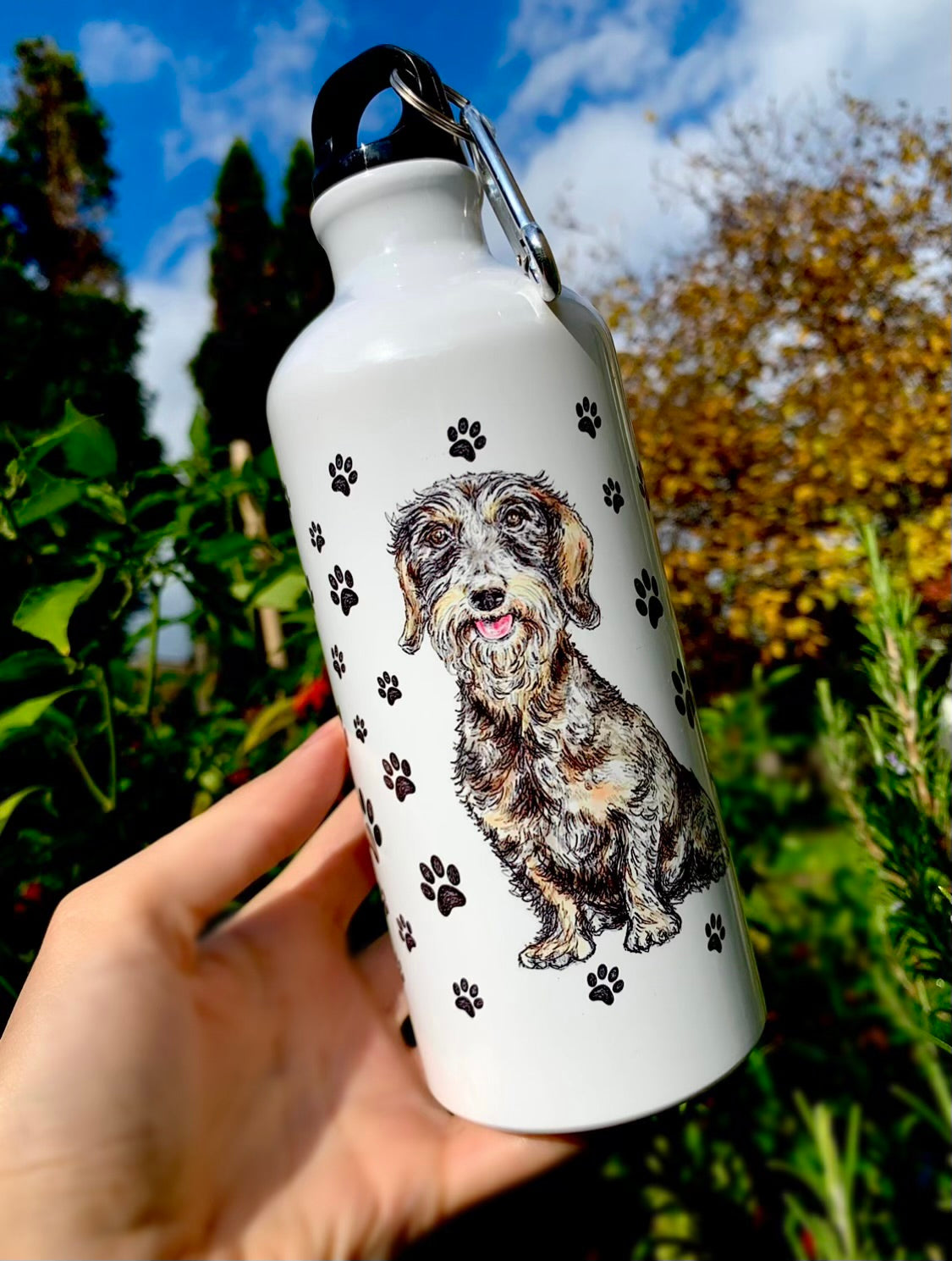 Ez a 600 ml-es szálkásszőrű tacskós kulacs kézzel rajzolt, részletgazdag illusztrációval készült, amely igazán egyedi és prémium megjelenést ad neki. Tartós fém kialakítása miatt ideális túrákhoz, sétákhoz és mindennapi használatra. Tökéletes ajándék tacskó gazdiknak, akik szeretik a különleges kutyás kiegészítőket.