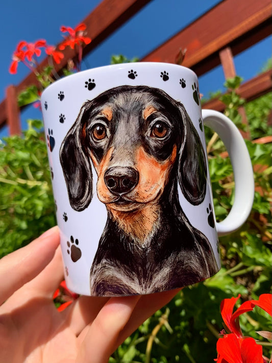 Prémium tacskós kerámia bögre kézzel festett cser tacskó portréval és egész alakos illusztrációval, fehér alapon fekete mancsnyom mintákkal, ajándék tacskós gazdiknak.