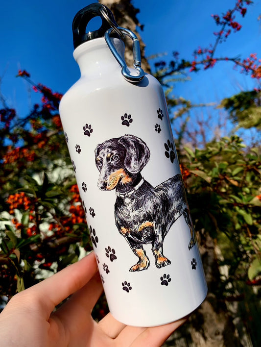 Ez a 600 ml-es tacskós fém kulacs kézzel festett, részletgazdag tacskó illusztrációval készült, amely igazán egyedi megjelenést biztosít. Könnyű, tartós és ideális választás mindennapi iváshoz vagy kirándulásokhoz. Tökéletes kutyás ajándék tacskó gazdiknak, akik prémium minőséget keresnek.