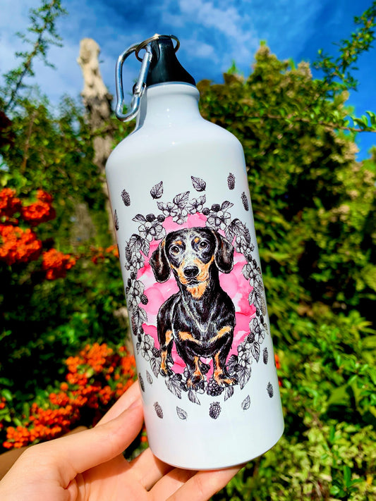 Ez a 600 ml-es tacskós fém kulacs kézzel rajzolt, részletgazdag tacskó illusztrációt visel, amely egyedi megjelenést ad minden gazdinak. Strapabíró, könnyű és mindennapi használatra tervezett kutyás kulacs, amely ideális túrázáshoz és sétákhoz is. Tökéletes ajándék tacskórajongóknak, akik prémium, tartós és különleges terméket keresnek.