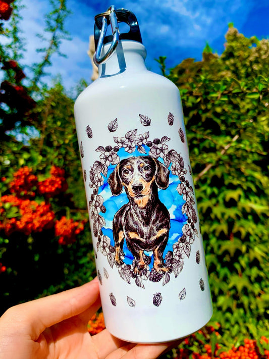 Prémium minőségű tacskós kulacs, amelyet kifejezetten tacskó gazdiknak terveztünk, kézzel rajzolt illusztrációval a palástján. A 600 ml-es űrtartalom biztosítja a kényelmes vízfogyasztást egész nap. Elegáns, tartós és igazán különleges kutyás ajándék.