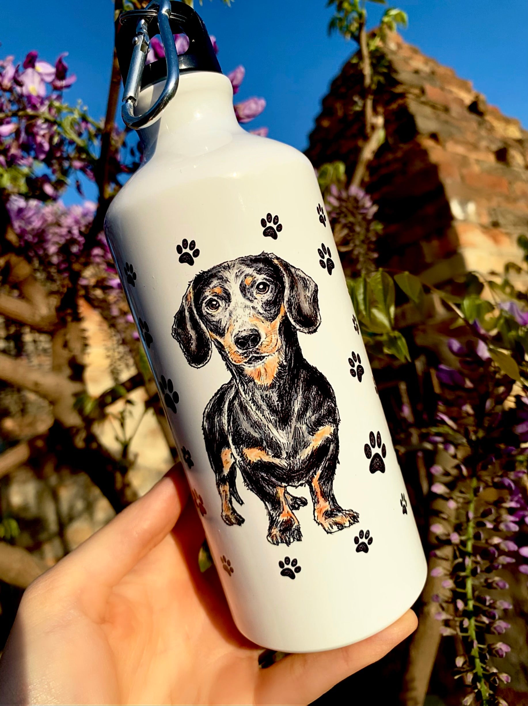 A kulacsot egyedi, akvarelles cser tacskó grafika és apró mancs minták díszítik, így igazán kedves és egyedi darab. Strapabíró fém anyaga miatt tökéletes kutyasétához, kiránduláshoz vagy napi vízfogyasztáshoz. Kiváló ajándék tacskó gazdiknak, akik a praktikumot és a szépséget keresik.