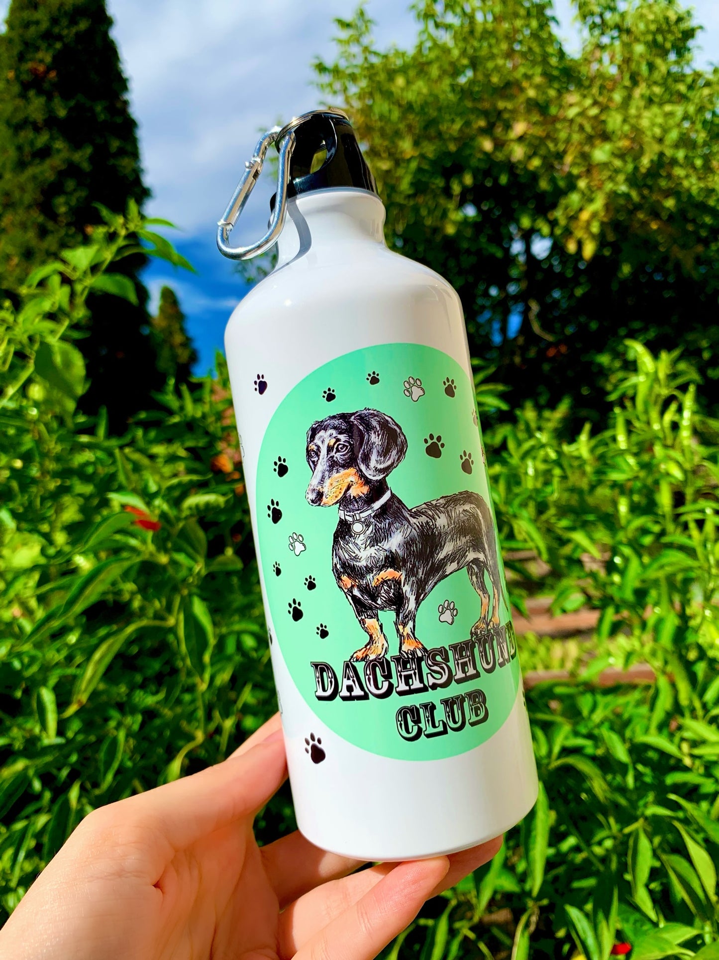 A tacskós kulacs színes, festett háttere modern, trendi megjelenést biztosít, amely kiemeli a kézzel rajzolt cser tacskó illusztrációt. 600 ml-es kapacitása miatt hosszabb utakra is ideális. Tacskó gazdiknak tervezett különleges, magyar műhelyben készült ajándék.