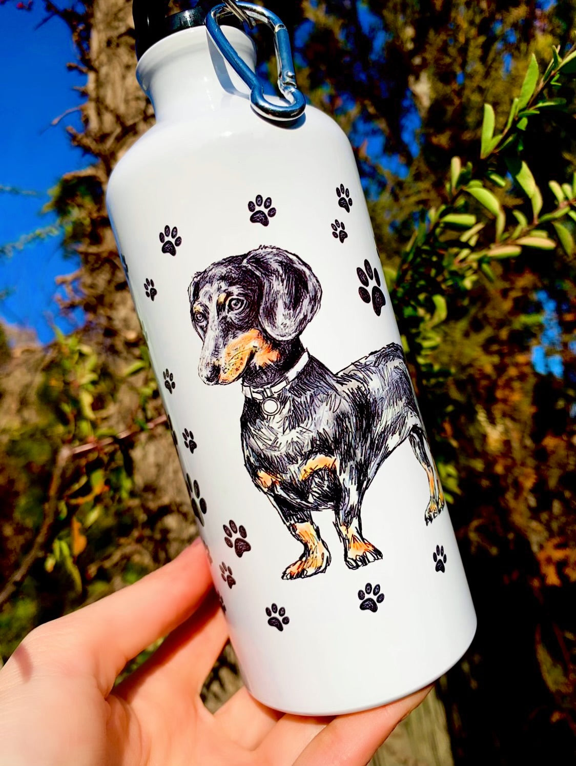 A tacskós sportkulacs könnyű, strapabíró és tökéletes aktív életmódhoz. A kézzel rajzolt tacskó illusztráció művészi karaktert ad a palacknak. Ideális választás tacskót kedvelőknek, akik praktikus, mégis látványos kulacsot szeretnének.