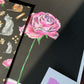 Rózsa mintás print fekete és pink háttérrel.